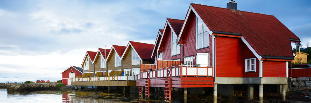 Red wooden cabins at campsite by the fjord in Molde, Norway