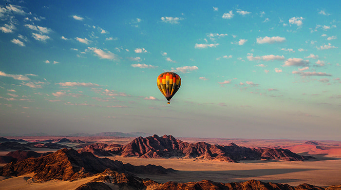 A hot air balloon flys over Namibia